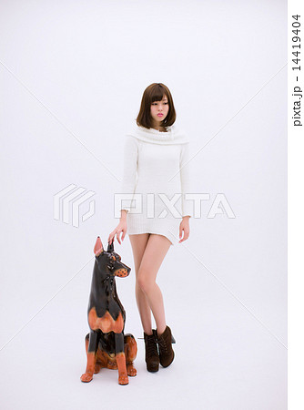 犬の置物の横に立つ若い女性の写真素材