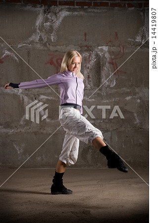 Beautiful hip hop girl dancing over grey brick wall Beautiful hip hop girl dancing over grey brick wall 14419807