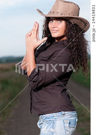 Beautiful cowboy woman posing in field Beautiful cowboy woman posing in field 14419831