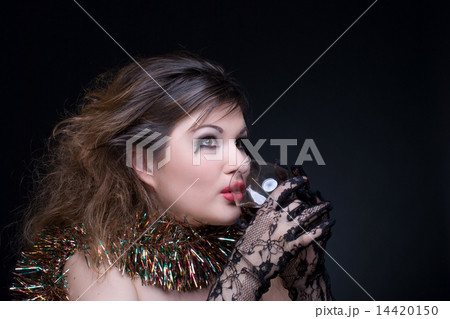 Closeup portrait of girl with red lips, tinsel and wineglass on 14420150
