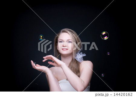 Closeup portrait of blond girl with soap bubbles on black 14420162