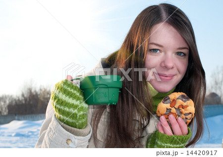 Girl on winter picnic with cup of tee and cookies 14420917