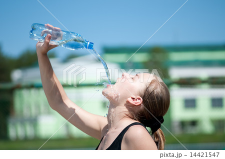 Yyoung woman drinking water after exercise Yyoung woman drinking water after exercise 14421547