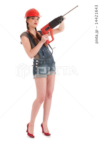 Young playful woman in jeans coverall holding perforator drill 14421643
