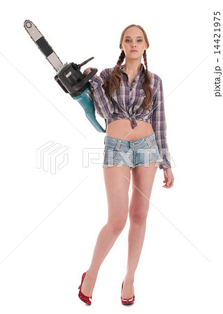 Young worker woman in jeans coverall with chain saw Young worker woman in jeans coverall with chain saw 14421975