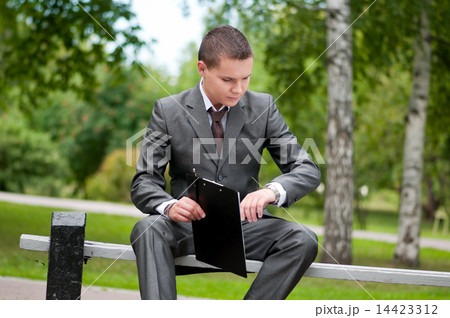 business man working with papers at park. Student business man working with papers at park. Student 14423312