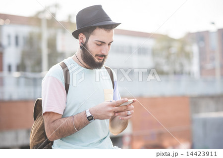 young handsome hipster gay modern man using smartphone young handsome hipster gay modern man using smartphone 14423911