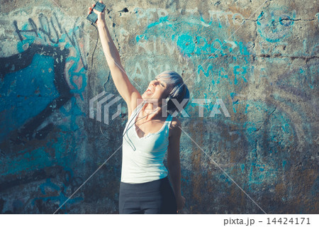 young beautiful short blue hair hipster woman with headphones mu 14424171