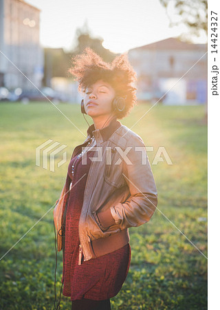 beautiful black curly hair african woman listening music with he 14424327