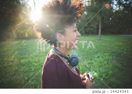 beautiful black curly hair african woman listening music with he 14424343