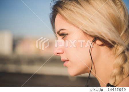 young beautiful blonde woman outdoor listening music young beautiful blonde woman outdoor listening music 14425049