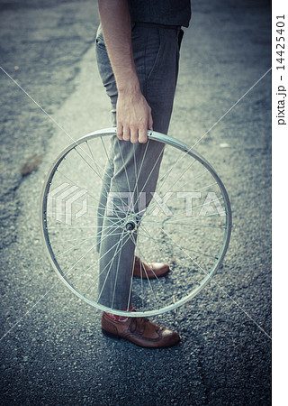 close up of legs shoes hipster man holding old bicycle wheel close up of legs shoes hipster man holding old bicycle wheel 14425401