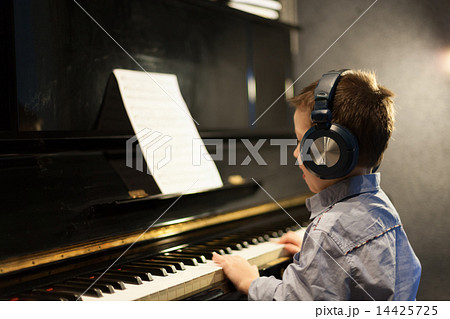 Boy listening to music and learning piano 14425725
