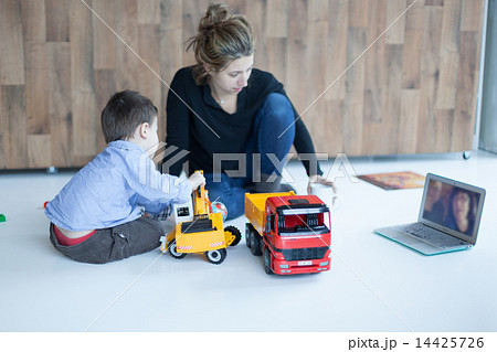 Boy playing toys with his mother video calling to her parents 14425726