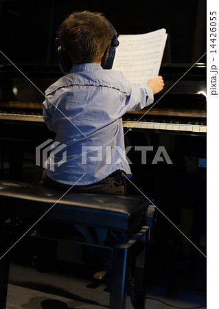 Rear view of a little boy learning piano 14426055