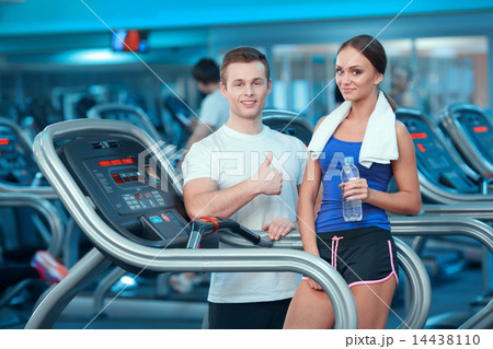 Beautiful girl in sports club with instructor 14438110