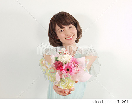 花を差し出す若い女性の写真素材