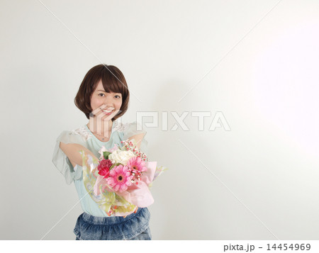 花を差し出す若い女性の写真素材