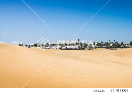Sand dunes in sunny day. Beautiful white hotel 14495365
