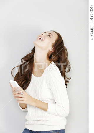 Woman laughing at her phone Woman laughing at her phone 14514045
