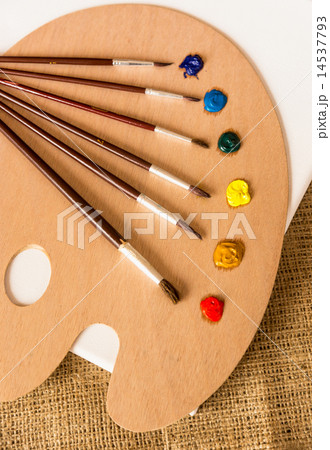 professional paintbrushes lying on wooden pallet with oil paints professional paintbrushes lying on wooden pallet with oil paints 14537793
