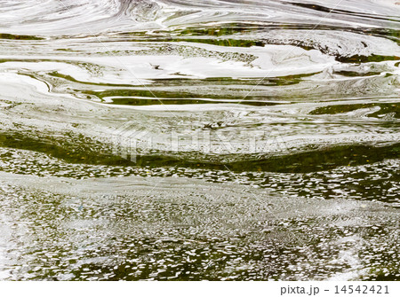 Abstract white foam swirls on green water Abstract white foam swirls on green water 14542421
