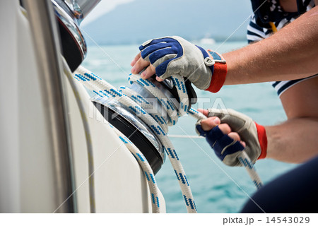 Winch and sailors hands on a sailboat Winch and sailors hands on a sailboat 14543029