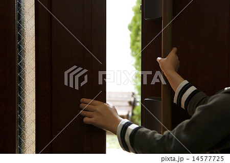 玄関ドアを開ける子供の手の写真素材