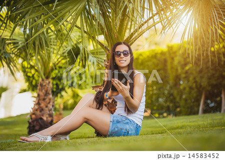 girl is talking on the phone in the palm garden 14583452