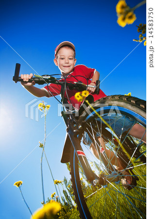 boy with bike standing against the blue sky boy with bike standing against the blue sky 14583750