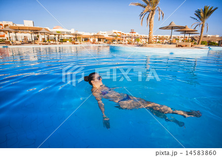 Woman swimming in a blue swimming pool Woman swimming in a blue swimming pool 14583860