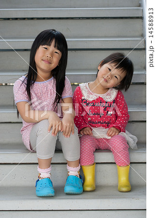 階段に座っている可愛い子供姉妹の二人の写真素材