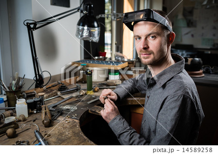 Jeweler working on wedding gold ring Jeweler working on wedding gold ring 14589258