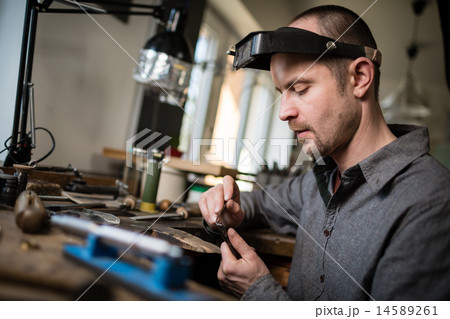 Jeweler working on unfinished ring 14589261