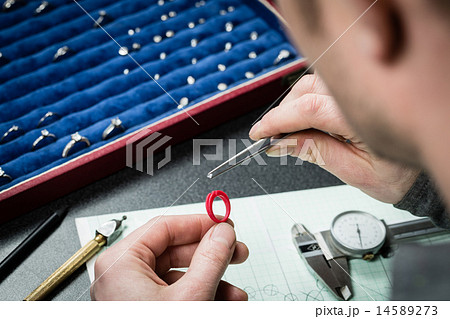 Jeweler working with wax model ring 14589273