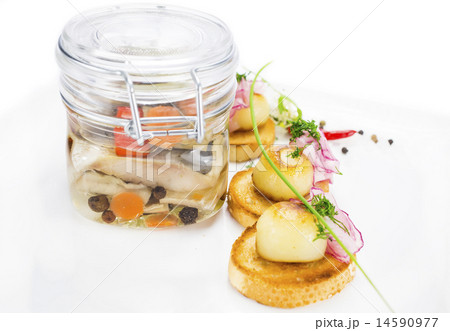 pickled herring in a glass jar with potato canapes 14590977