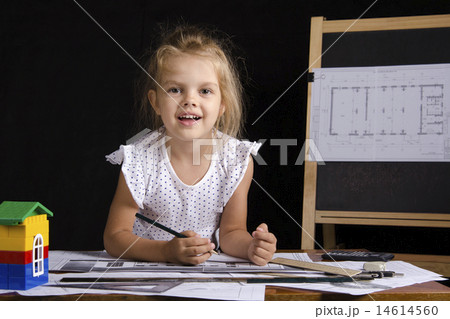 Girl-architect sitting behind Desk and looks in frame 14614560
