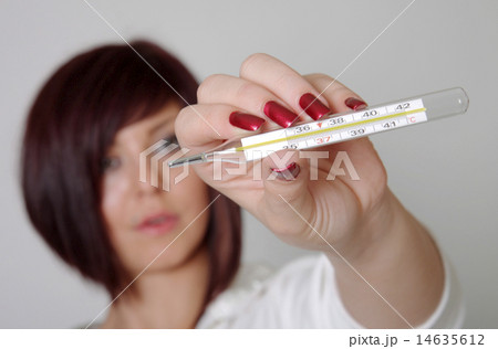 Attractive Caucasian female checking her temperature 14635612