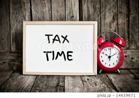 Tax time message note on white board with redclock 14639671