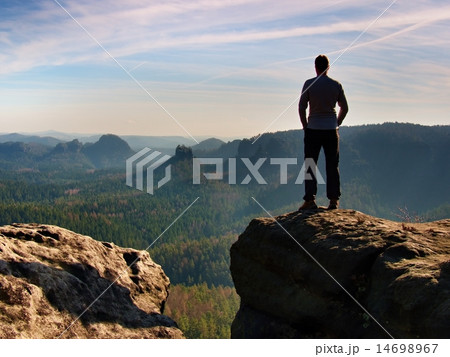 Hiker is standing on the peak of sandstone rock Hiker is standing on the peak of sandstone rock 14698967