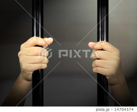 Hands of the prisoner on a steel lattice 14704374