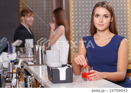 Woman sits at the counter of bar 14709042