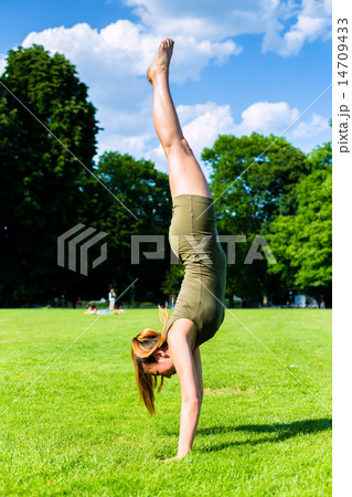 Woman doing handstand in park 14709433