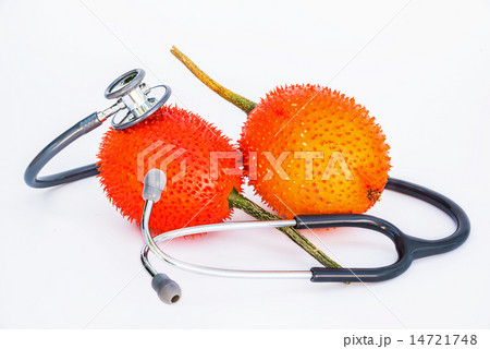 Gac fruit and Stethoscope on white background Gac fruit and Stethoscope on white background 14721748