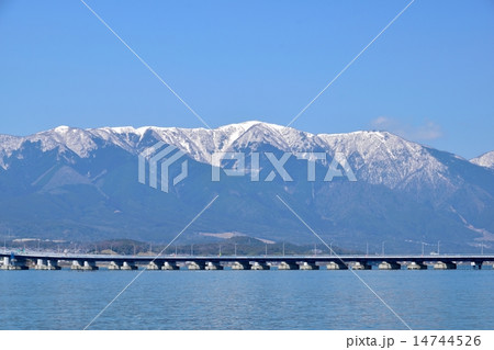 早春の琵琶湖を通る琵琶湖大橋と背景になる雪の比良山 早春の琵琶湖を通る琵琶湖大橋と背景になる雪の比良山 14744526