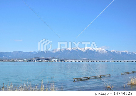 早春の琵琶湖を通る琵琶湖大橋と背景になる雪の比良山 14744528