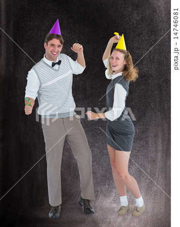 Composite image of geeky couple dancing with party hat 14746081