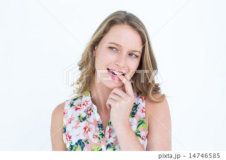 Smiling woman biting her finger Smiling woman biting her finger 14746585