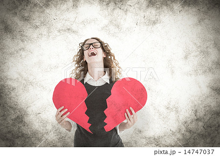 Composite image of geeky hipster holding a broken heart card Composite image of geeky hipster holding a broken heart card 14747037