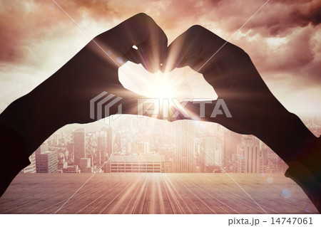 Composite image of woman making heart shape with hands Composite image of woman making heart shape with hands 14747061